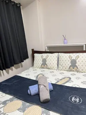 a bedroom with a bed with two towels on it at Cozy 1-BR Retreat Near MOA Pool view in Manila