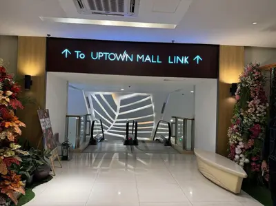 a mall lobby with a sign that reads to uptown mall link at Comfy 1BR At Uptown BGC in Manila