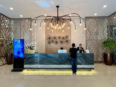 a man standing at a counter in a lobby at Comfy 1BR At Uptown BGC in Manila