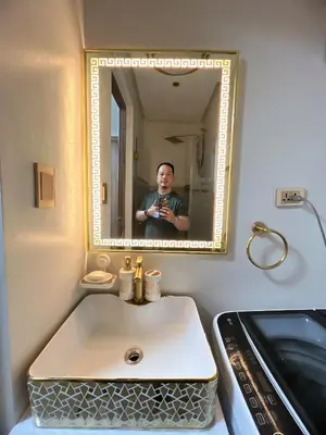 a man taking a picture of a sink in a bathroom at Hadisha Suite Spring Residence in Manila