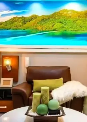 a room with a couch and a table with a television at Gramercy Century City Makati in Manila