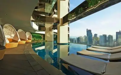 a building with a pool with a view of a city at Gramercy Century City Makati in Manila