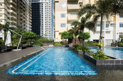 a swimming pool in the middle of a building with palm trees at Skyline Stay in Manhattan in Manila