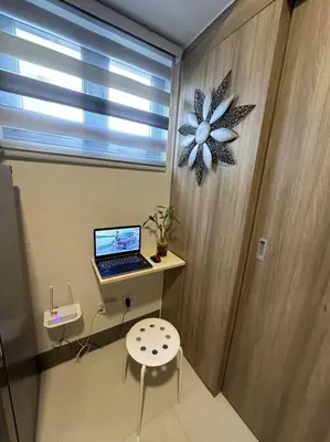 a laptop computer on a desk in a room with a window at Vince Cozy Staycation in Manila