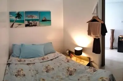 a bedroom with a bed and a painting on the wall at Heart of Makati in Manila