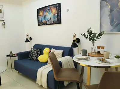 a living room with a blue couch and a table at Heart of Makati in Manila
