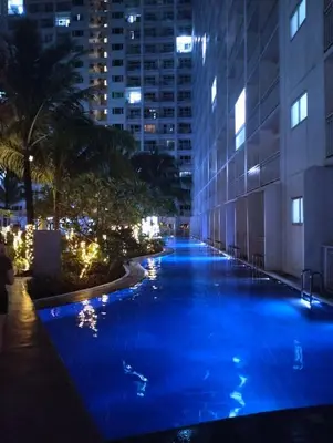 a pool in the middle of a building at night at Cozy Home in Mall of Asia - Aseana Pasay in Manila
