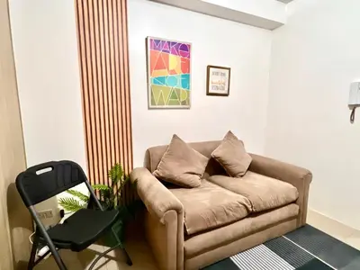 a living room with a couch and a chair at Cozy Home in Mall of Asia - Aseana Pasay in Manila