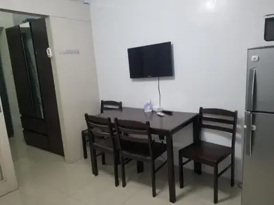 a dining room with a table and chairs and a refrigerator at SEA RESIDENCES AFFORDABLE STAYCATIONs in Manila