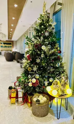 a christmas tree in a lobby with presents under it at Urban Luxe Stay at Shore 3 in Manila