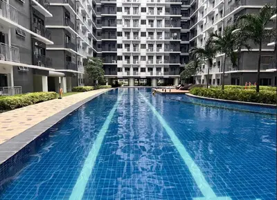 a large swimming pool in front of a building at Cozy Hearth Loft at Shore 3 in Manila