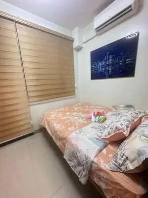 a bedroom with a bed and a wall with windows at Nalin house SHORE 2 Residences in Manila
