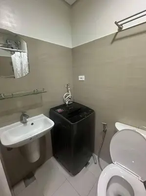 a bathroom with a white toilet and a sink at Nalin house SHORE 2 Residences in Manila