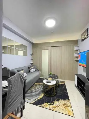 a living room with a couch and a tv at Shore Residences Staycation by K in Manila