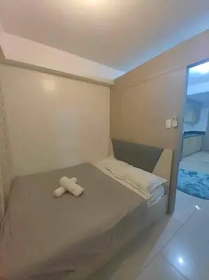 a small bedroom with a bed with two towels on it at Shore Staycation - Mall of Asia in Manila