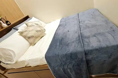 a bed with white sheets and pillows on it at 1BR self-contained CONDO in Makati with amenities! in Manila