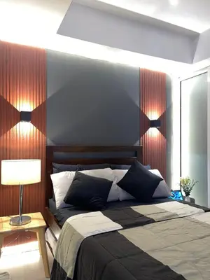 a bedroom with a large bed with a red striped wall at La Primera Deluxe in Manila