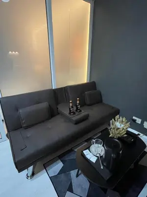 a black couch in a living room with a table at La Primera Deluxe in Manila