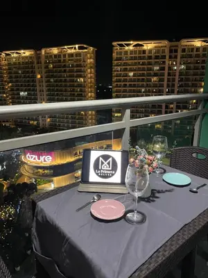a table with a laptop on top of a balcony at La Primera Deluxe in Manila