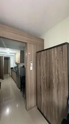 a living room with a sliding door and a kitchen at Casa Antonietta at Shores Residences in Manila