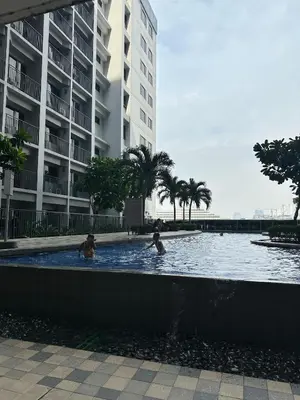 two people swimming in a swimming pool in a building at Casa Antonietta at Shores Residences in Manila