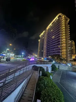 a large building at night with a parking lot at Azure Urban Dream Staycation in Manila