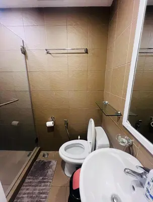 a bathroom with a toilet and a sink at Porto Vita Towers in Manila