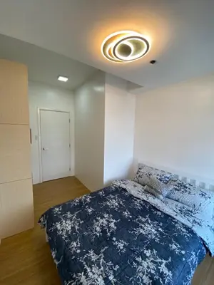a bedroom with a large bed with a blue blanket at Porto Vita Towers in Manila