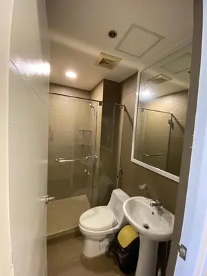 a bathroom with a shower and a toilet and a sink at Porto Vita Towers in Manila