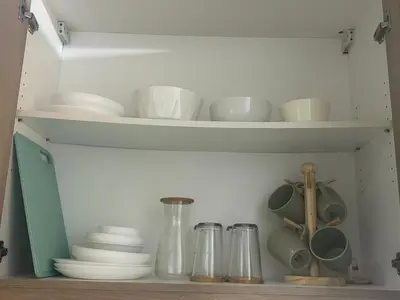 a cupboard filled with bowls and plates and utensils at Shore 1 Residences Tower B in Manila