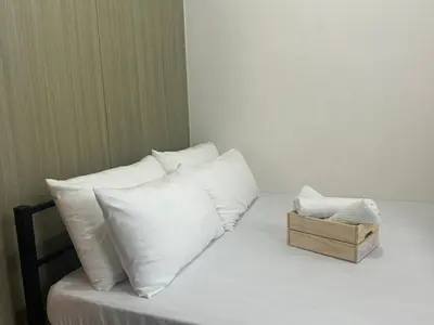 a bed with white pillows and a wooden box on it at Shore 1 Residences Tower B in Manila