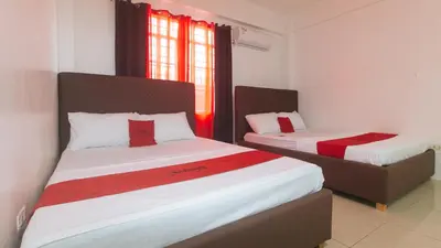 a bedroom with two beds with red and white sheets at RedDoorz at Najar Residences near NAIA Terminal in Manila