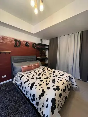 a bedroom with a bed with a black and white comforter at Alphas Haven in Manila
