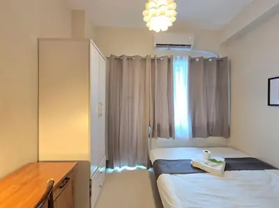 a small bedroom with a bed and a window at 1BR Condotel with Balcony at FAME Residences #FM59 in Manila