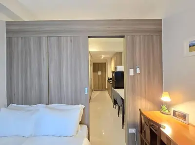 a hotel room with a bed and a desk and a kitchen at 1BR Condotel with Balcony at FAME Residences #FM59 in Manila