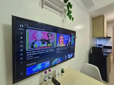 a large flat screen tv hanging on a wall at 1BR Condotel with Balcony at SM Light Residences #LT08 in Manila