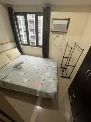 a small bed in a room with a window at Shore Family Suite 2 Beds WiFi TV Netflix Near MOA 9120 in Manila