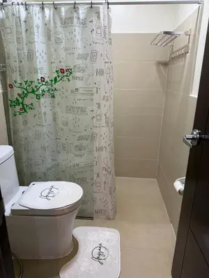 a bathroom with a toilet and a shower curtain at Angsana Breeze at Paseo Verde Las Piñas in Manila