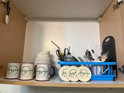 a shelf with coffee cups and utensils on it at Angsana Breeze at Paseo Verde Las Piñas in Manila