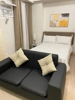 a living room with a couch and a bed at SMDC Park Residences near SM City Sta Rosa unit 1 in Ibaba