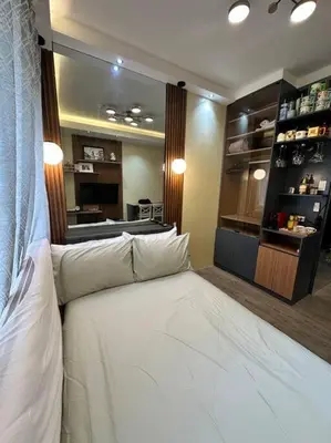 a large white bed in a room with a kitchen at Cozy Unit Right by the Pool with Massage in Silang