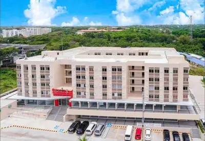 an apartment building with cars parked in front of it at Cozy Unit Right by the Pool with Massage in Silang