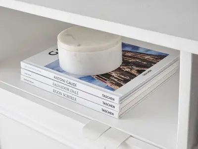 a stack of books on a shelf with a roll of soap at King Bed, Washer, Air Dry, Sauna, Gym & Pool Access, FAST Wi-Fi, Elegant Studio, Near Venice Grand Canal Mall, Walking Distance Britsh Embassy, 5 min drive to BGC, 10 min drive to Manila Airport NAIA 3 in Manila