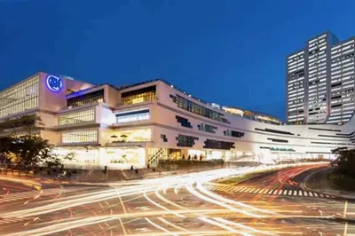 a large building with cars on a city street at Cozy Home in BGC in Manila