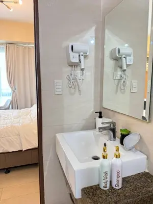 a bathroom with a white sink and a mirror at Condotel near NAIA T3 Airport in Manila