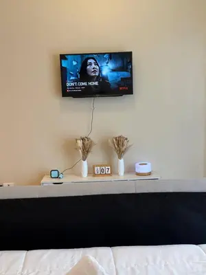 a flat screen tv on a wall above a bed at Condotel near NAIA T3 Airport in Manila