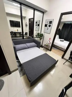 a room with a bed and a living room at The Room of Requirement in Manila