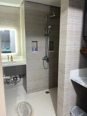 a bathroom with a shower and a sink at Condotel 1 Bedroom Across SM Aura in Manila