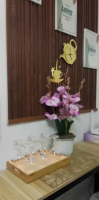 a table with glasses and a vase of flowers on it at TresMaria'Staycation in Manila