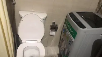 a bathroom with a toilet and a trash can at TresMaria'Staycation in Manila